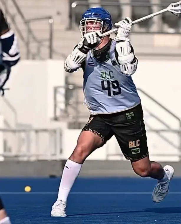 A Bangkok LC player in a white number 49 jersey drives forward with his stick raised